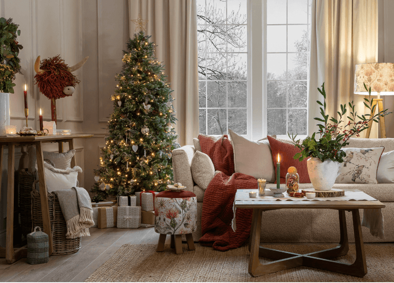 A living room featuring a festive tree and a range of luxury Christmas decorations.