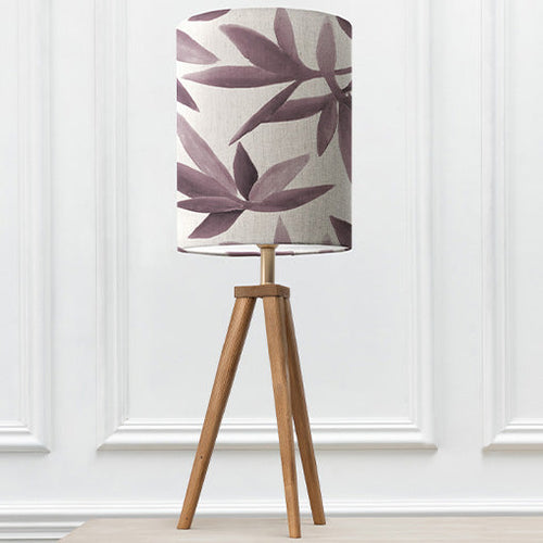 A wooden table lamp decorated with a floral purple lamp shade.